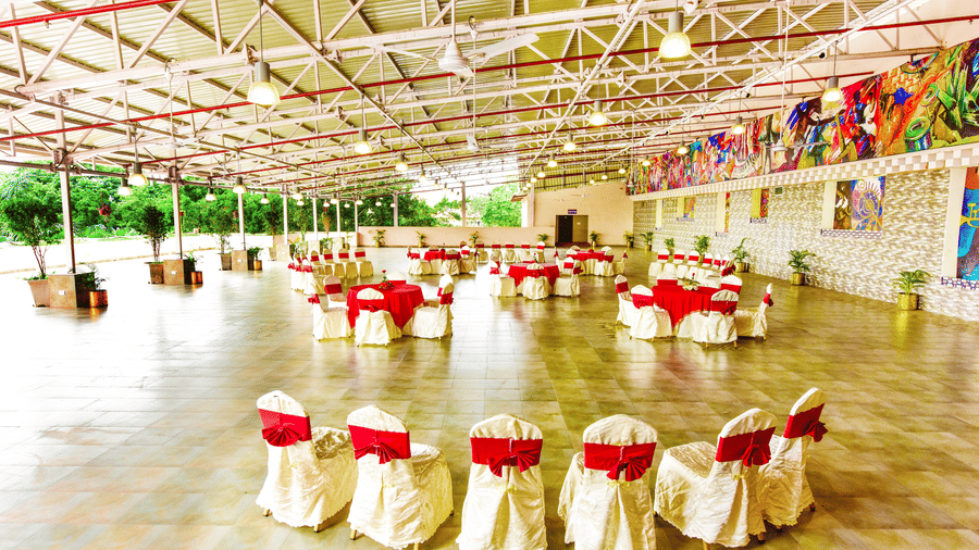 Well-lit banquet hall, with comprehensive decorations, ready to host a festive event.