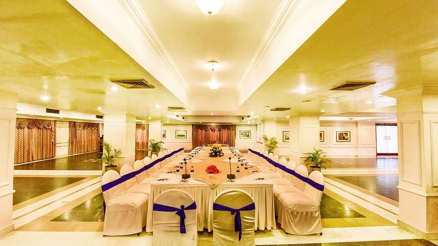 Well-lit banquet hall, with comprehensive decorations, ready to host a festive event.
