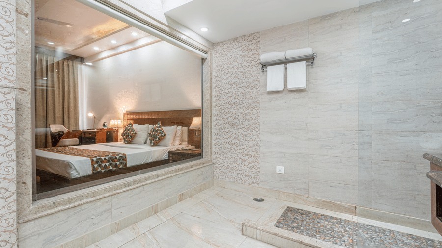 Cosy bedroom with warm lighting, large bed, and stylish mirrored wall feature at The Solitaire Resort, creating a perfect retreat for comfort and peaceful rest.