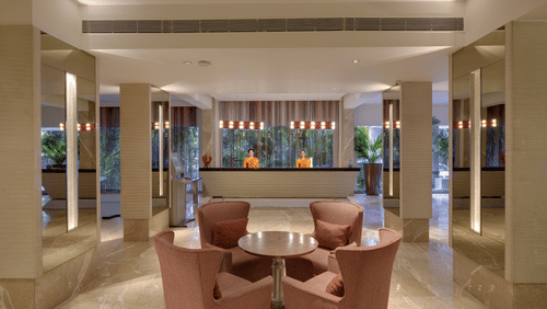  A welcoming hotel lobby with a front desk, comfortable seating, and elegant lighting, possibly at Pride Premier Pune