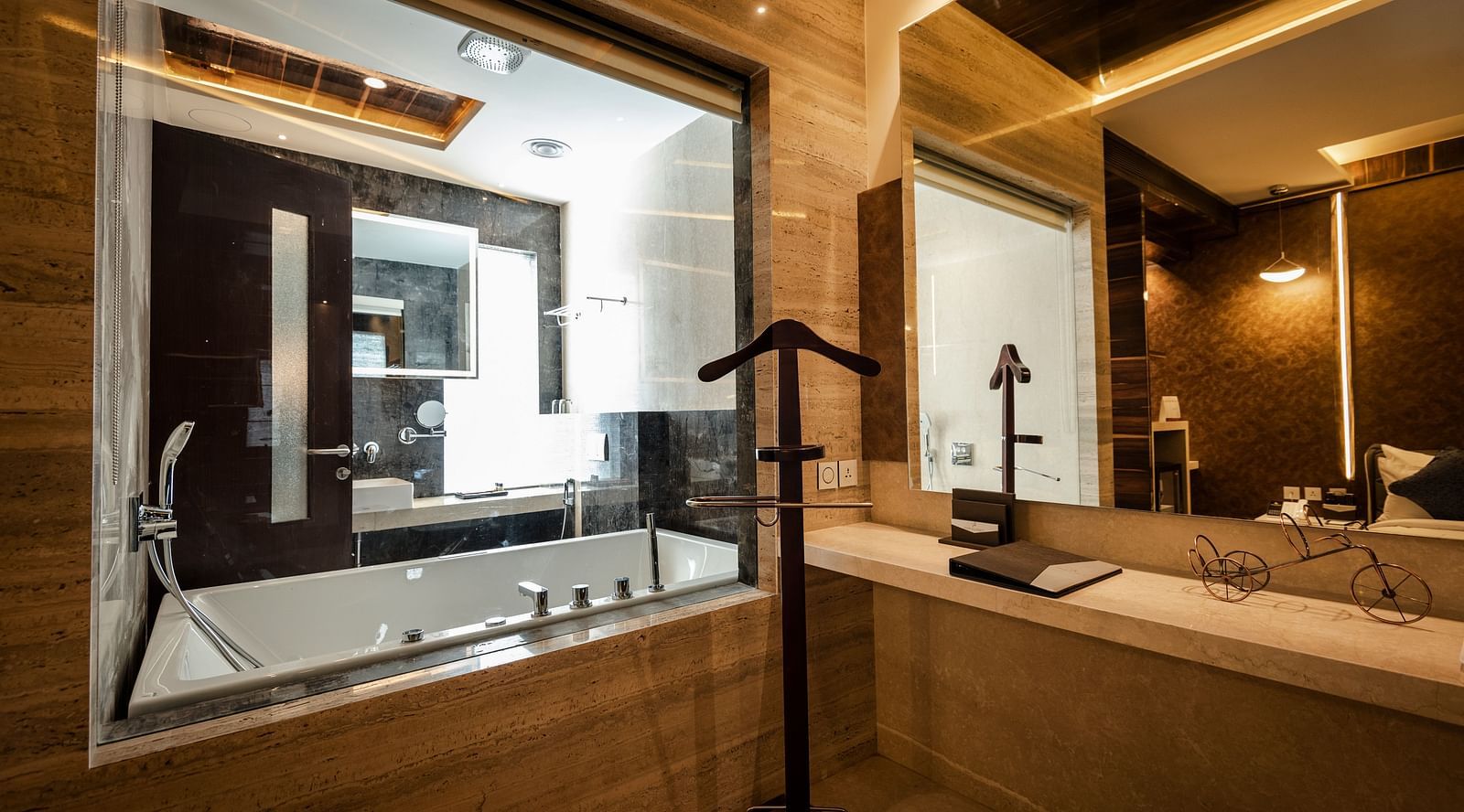 a view of the bedroom from glass-enclosed washroom of Junior Suite at Hotel Park Elanza, Coimbatore