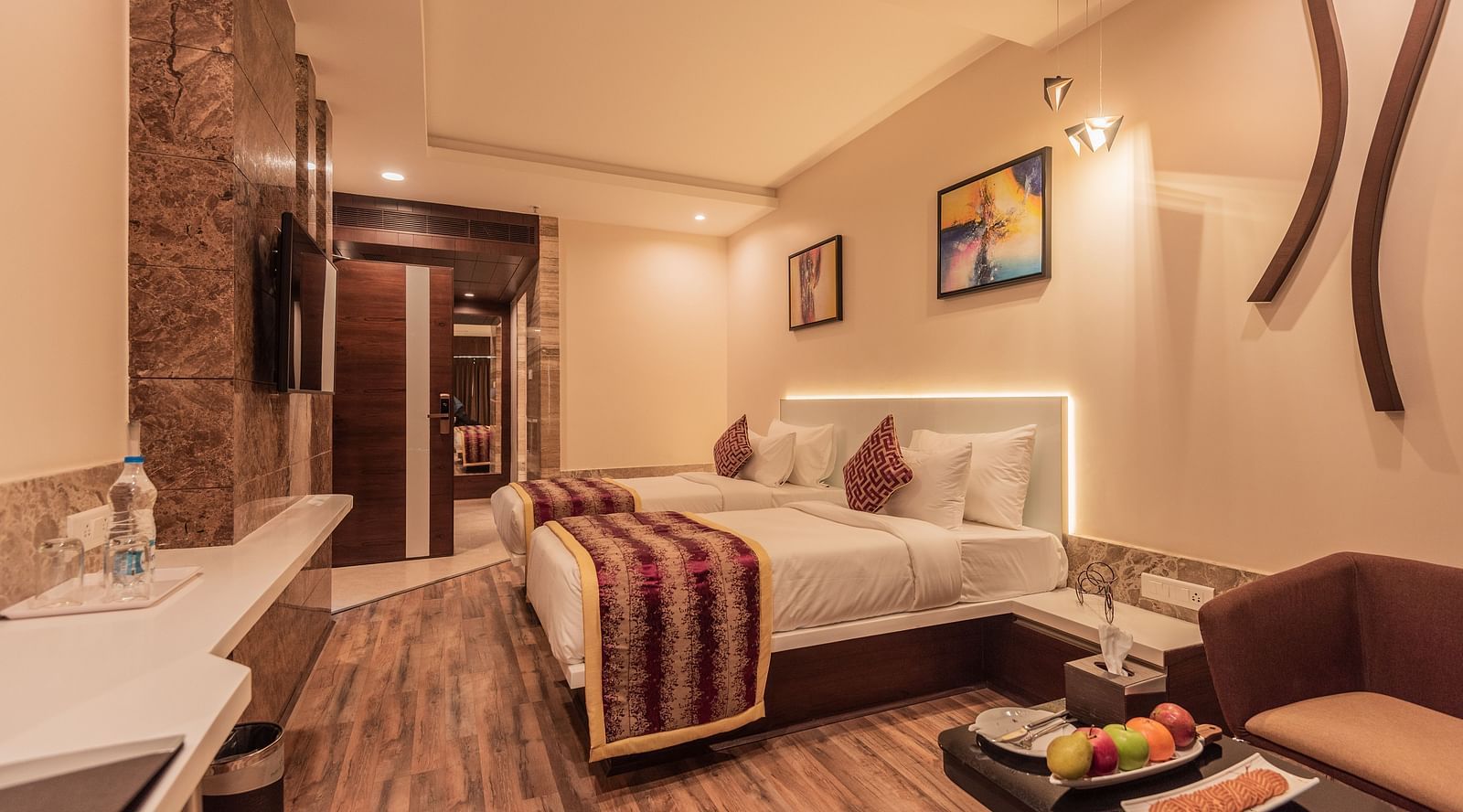 a view of premium Room decked with 2 beds, television and a sofa at Hotel Park Elanza, Coimbatore
