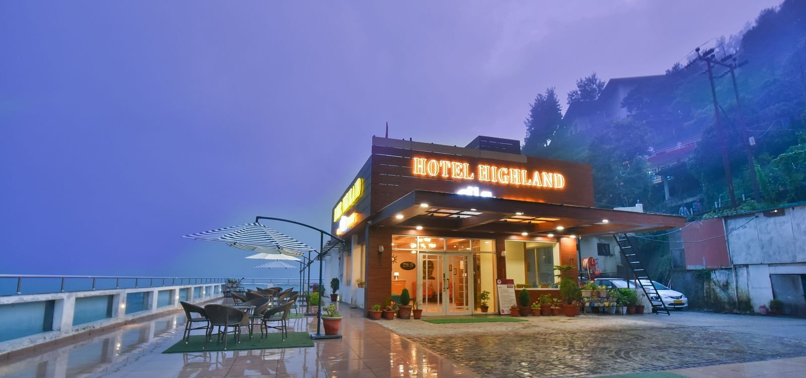View of the terrace at DLS Highland Resort and Spa, Mussoorie with chairs around tables.