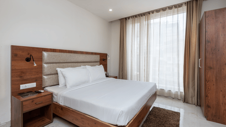 A Deluxe Room featuring a king size bed and a stylish patterned headboard at DLS The Classio
