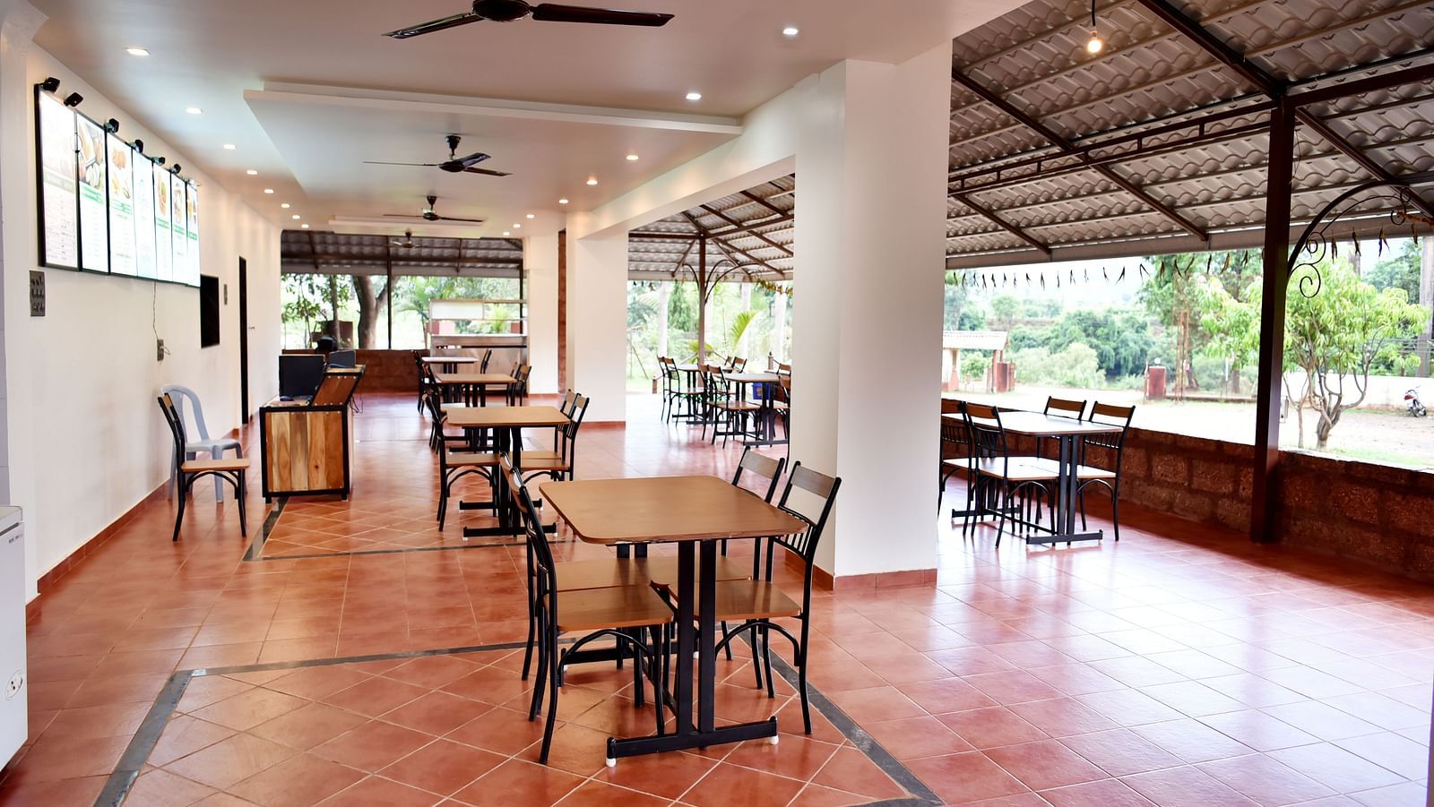An interior view of the restaurant at Riverside Inn, featuring neatly arranged tables and chairs, with a ceiling fan overhead.