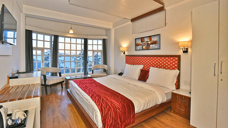 Bedroom with a fancy ceiling and warm illuminating lights at DLS Hillcrest Resort, Shimla.