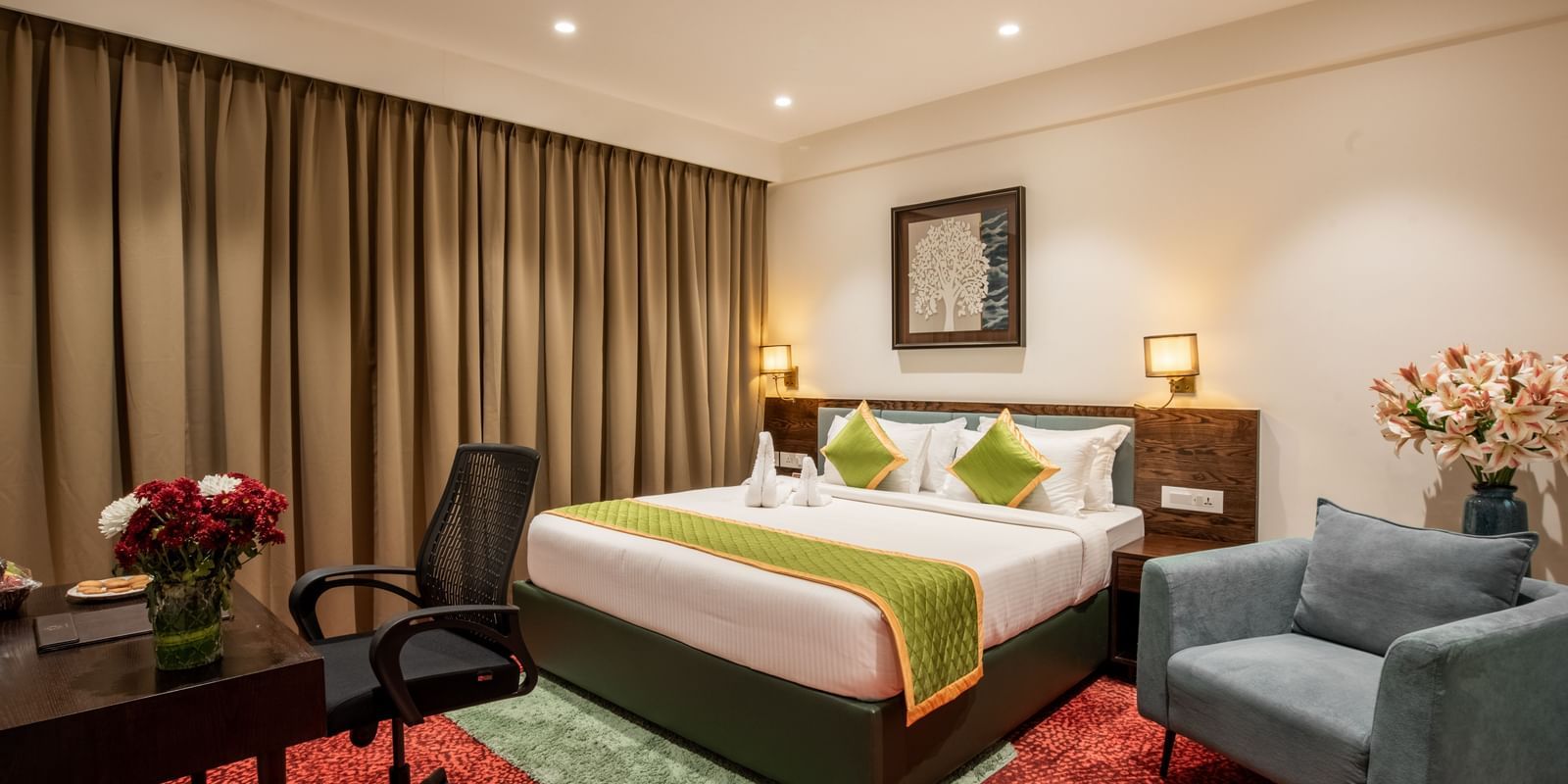 Elegant room with king size bed, seating area, and modern decor at Hotel Royal Regency Chennai