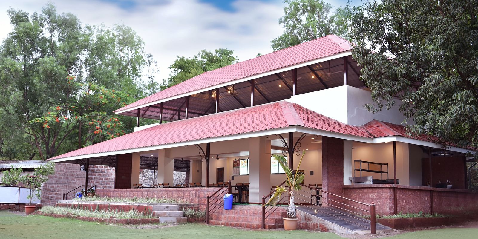 A side view of the restaurant facade at Riverside Inn, surrounded by plants and trees.