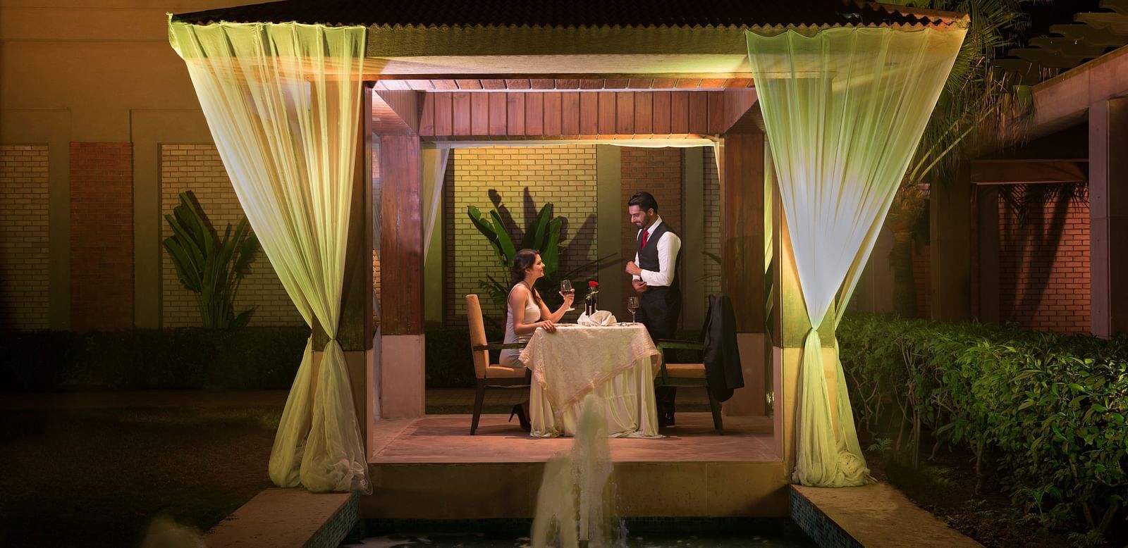 A couple enjoying a romantic dinner in an open-air setting at Nirvana Luxury Hotel, Ludhiana.