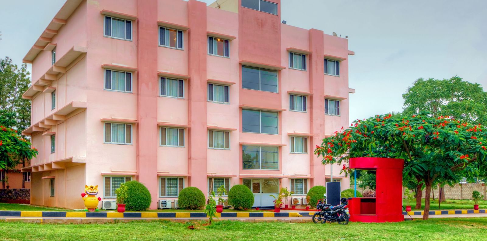 Exterior of Greens Inn with a lawn in front of it - Beautiful Hotel Grounds in Hyderabad.