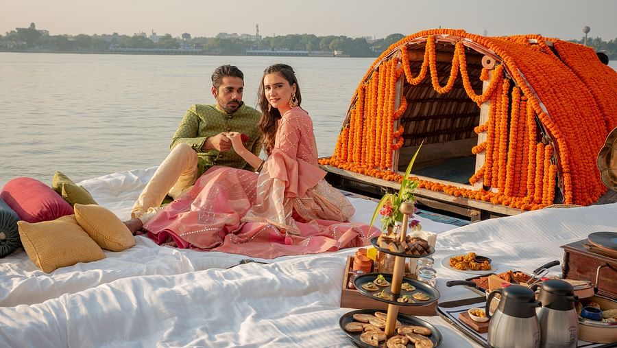 a newly wed couple sitting on a boat decorated with wedding ornaments - polo floatel kolkata