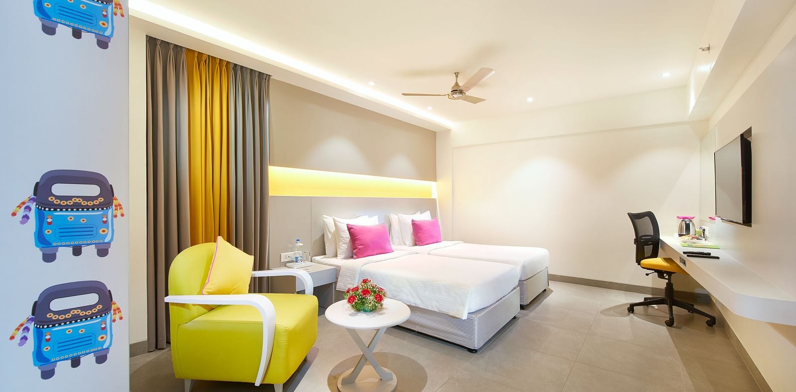 side view of a bedroom with a working table and a chair at  Zibe Salem by GRT Hotels