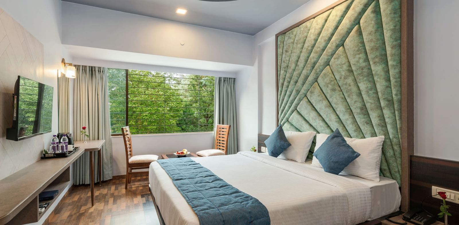 Chic bedroom at Emerald Retreat, Tungarli with a velvet headboard, soothing tones, and garden-facing windows.