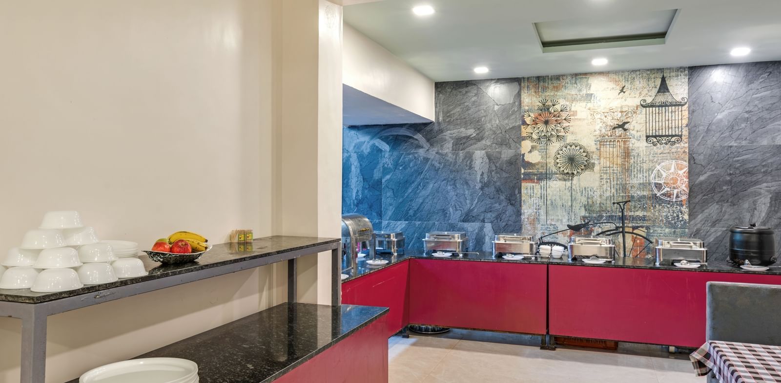 Buffet counter setup with white ceramics and steel utensils in the dining area at Emerald Retreat, Tungarli.