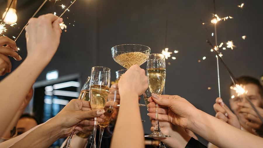 A close up shot of a group of people toasting  glasses and holding firecrackers