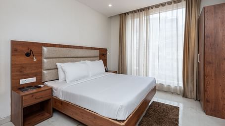 A Deluxe Room featuring a king size bed and a stylish patterned headboard at DLS The Classio