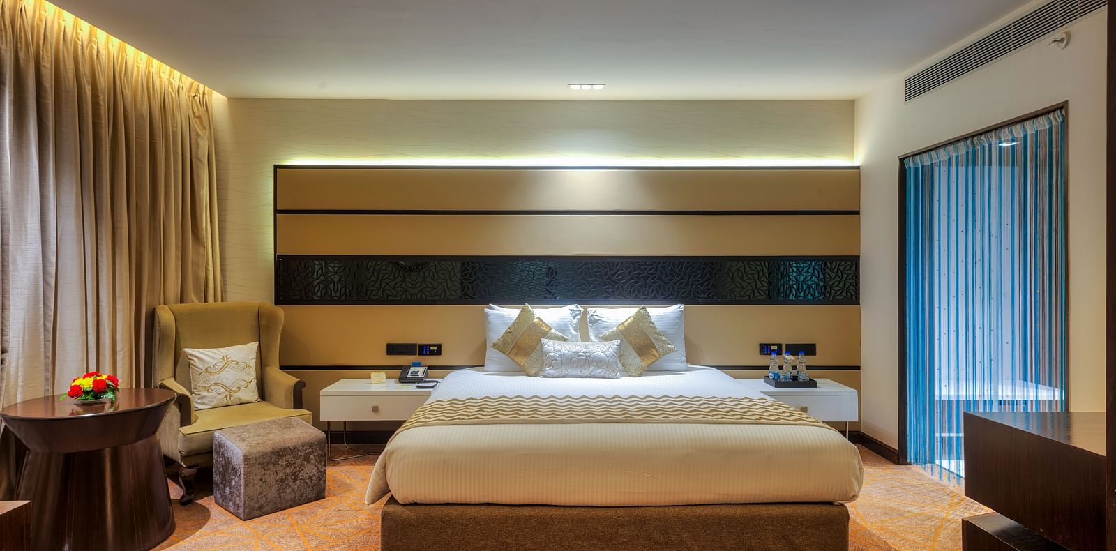 Theme Suite with a king size bed and a sofa chair at Grand Chennai By GRT Hotels.