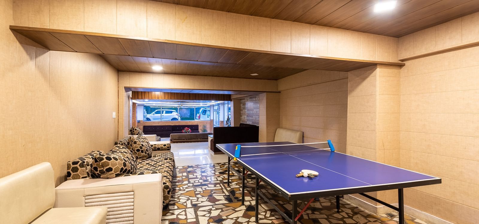 Image of a table tennis zone kept in the lobby with a white couch in the side | DLS Anupam Resort, Dharamshala