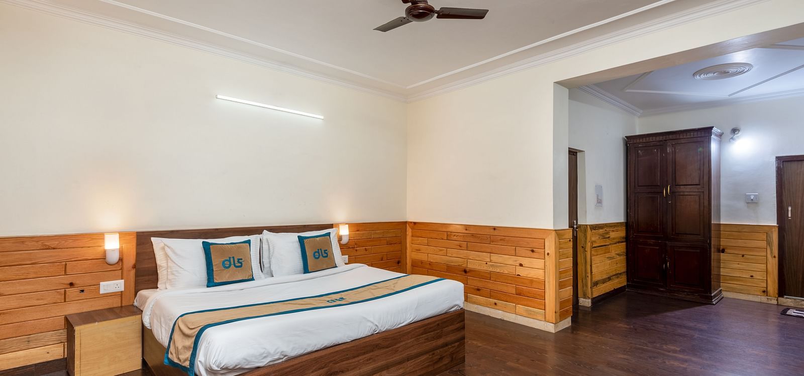 Image of well furnished room featuring a king size bed and a large open space with wooden flooring | DLS Anupam Resort, Dharamshala