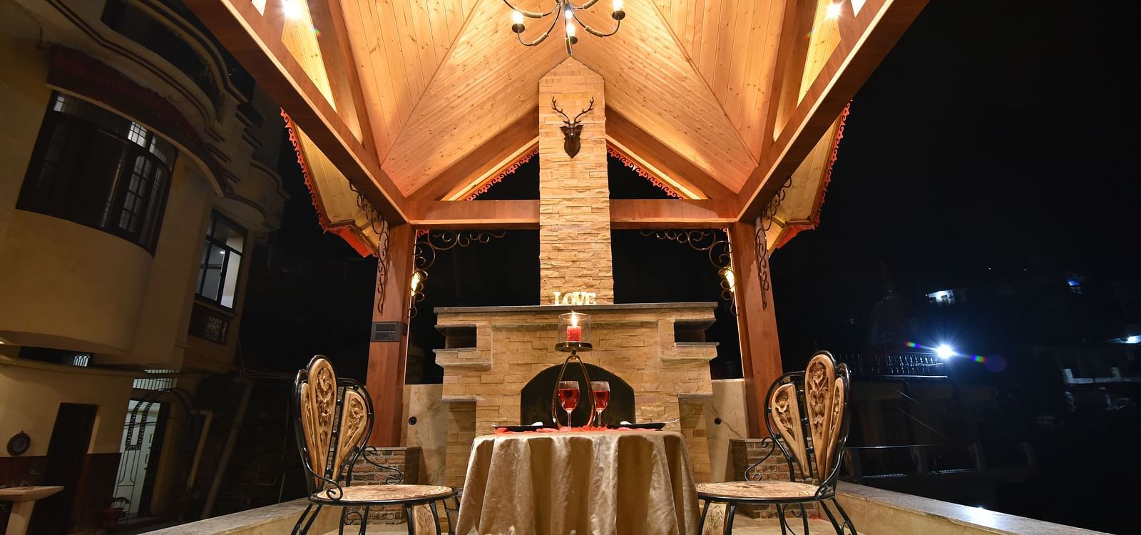 A Gazebo at DLS Dalhousie Valley Resort with beautiful chairs, table and a chandelier 