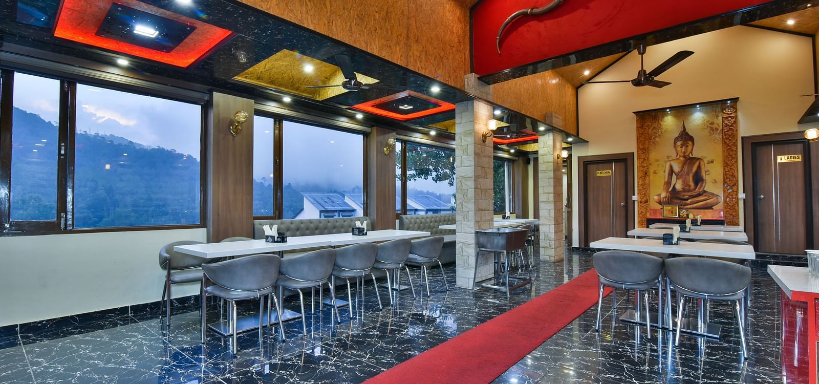 Restaurant at DLS Dalhousie Valley Resort with chairs, tables and serene views