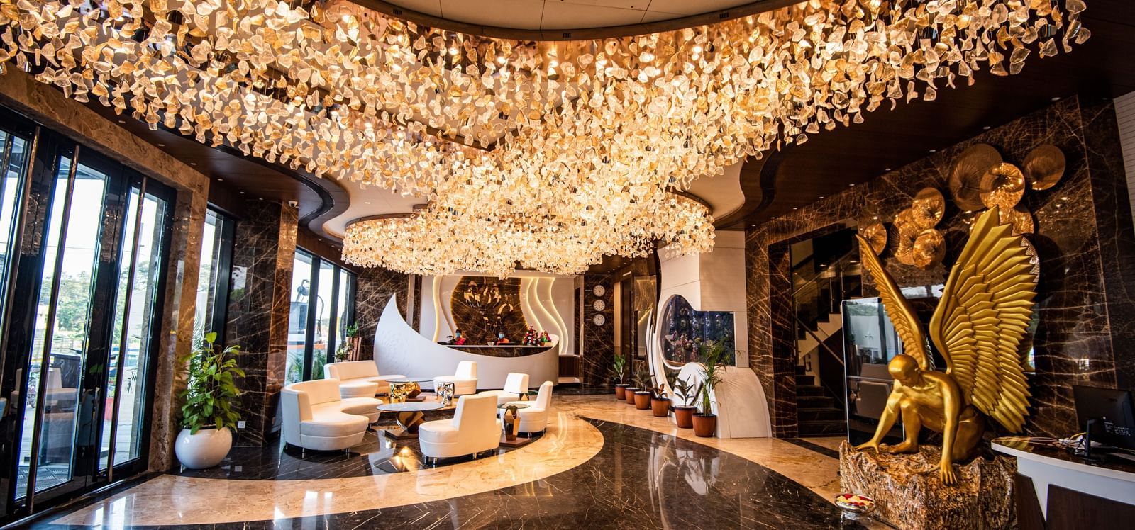 Lobby of Hotel Park Elanza, Coimbatore decked with bright lights and plush seating arrangements close to the reception area