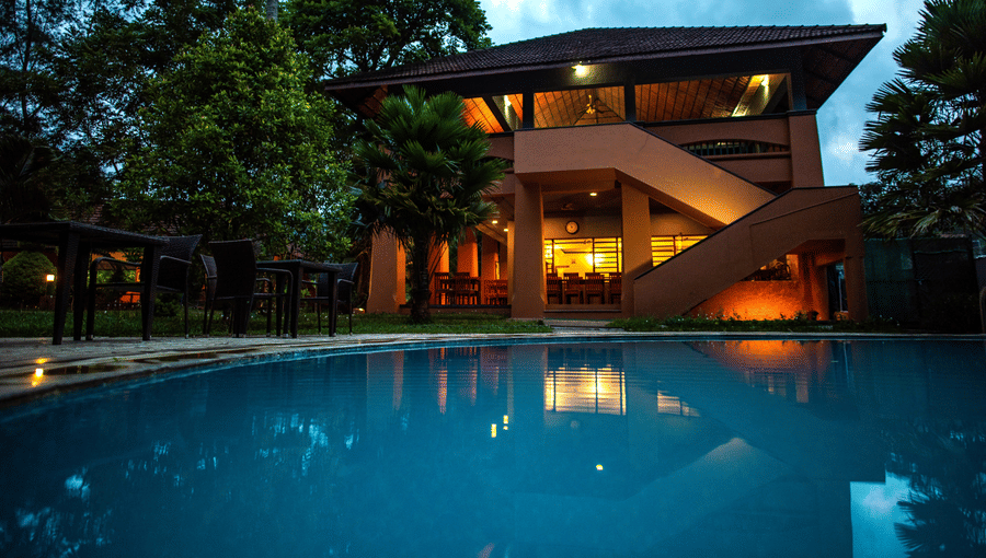 A serene poolside view surrounded by greenery at one of the finest resorts in Thekkady, offering a tranquil retreat at Abad Green Forest, Thekkady.
