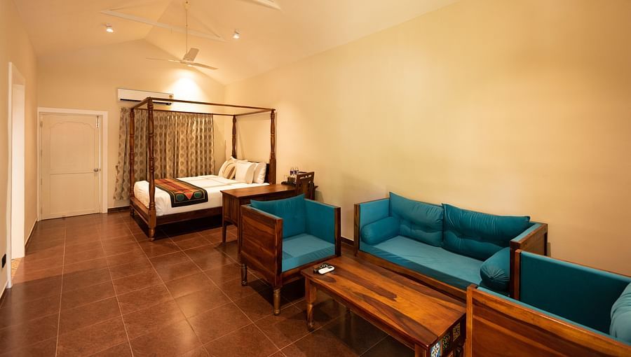 another view of sofas and a double bed inside Suite Room at Ibex River Resort, Pollachi