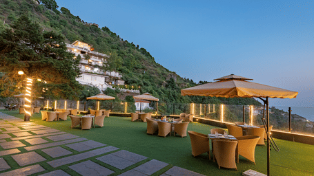 Comfortable seating in the lawn surrounded by hills at dusk at DLS Highland Resort and Spa, Mussoorie.
