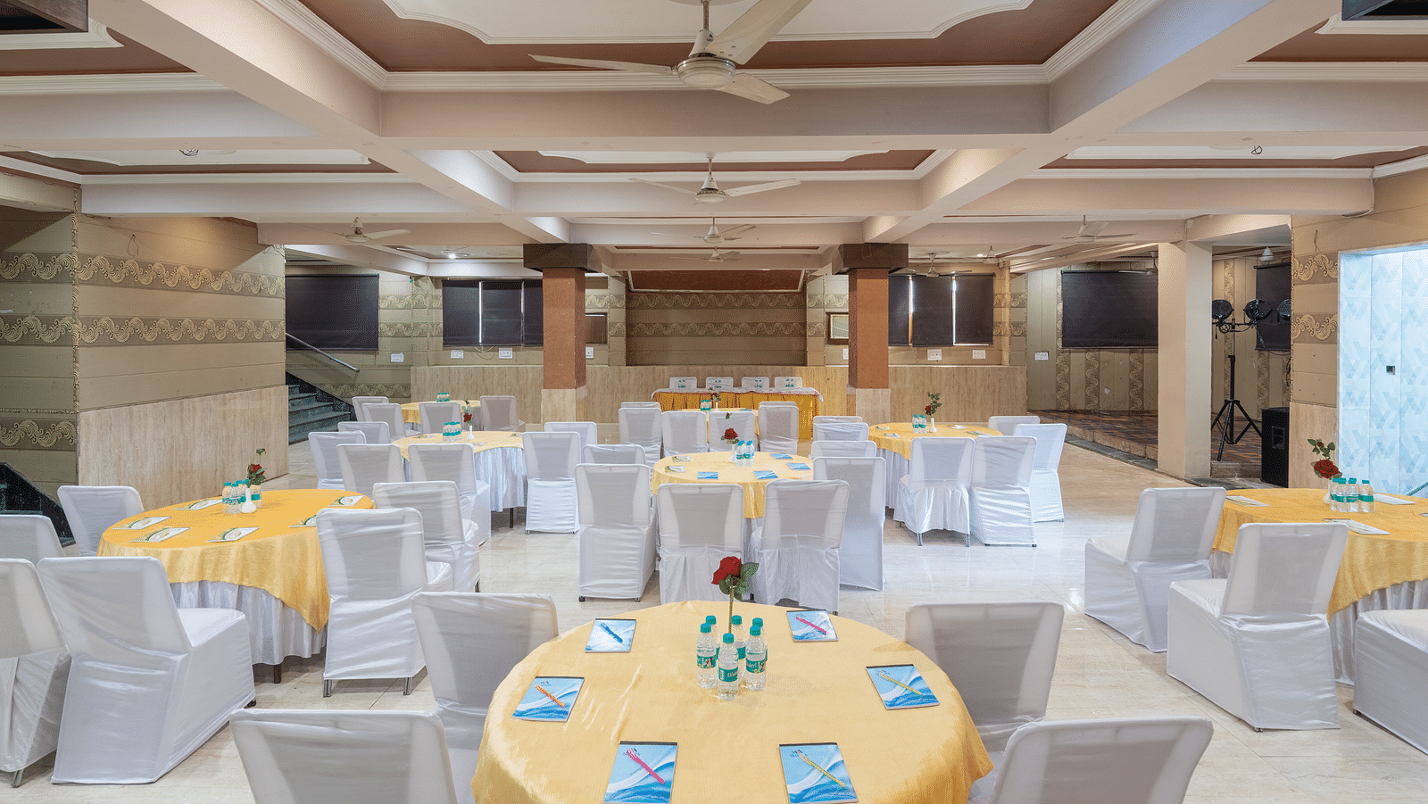 Banquet hall with round tables and chairs at DLS Park Grace, Haridwar.
