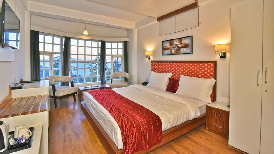 Bedroom with a fancy ceiling and warm illuminating lights at DLS Hillcrest Resort, Shimla.