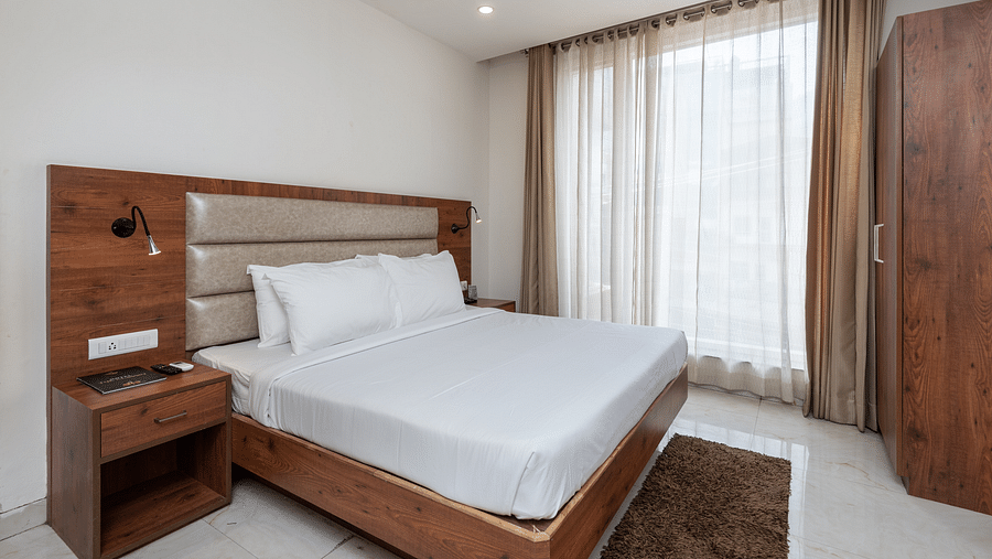 A Deluxe Room featuring a king size bed and a stylish patterned headboard at DLS The Classio
