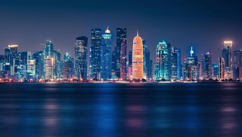A view of Doha city line at night with the lights reflecting in the water