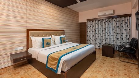Overview of Deluxe Non view room at DLS Spring Valley resort  Dharamshala featuring a  king bed, table, chairs, AC and a TV