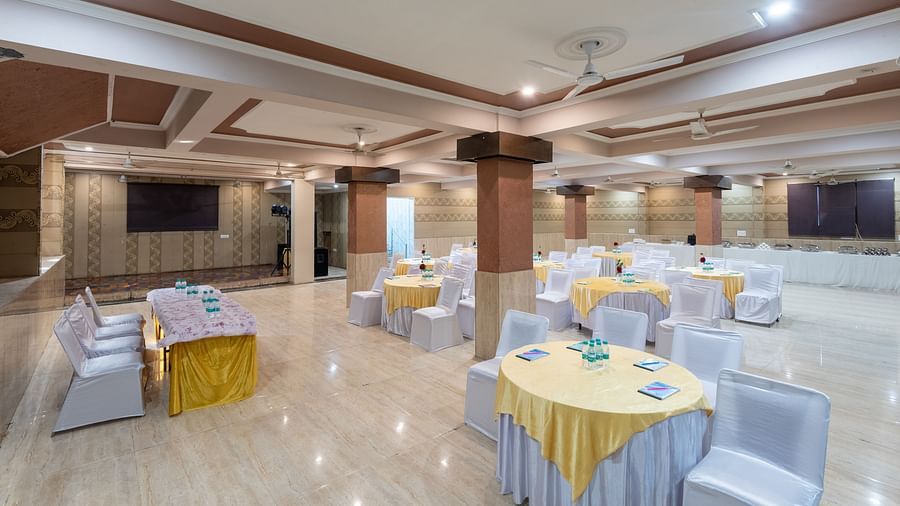 Banquet hall with seating arrangements and water bottles on the tables at DLS Park Grace, Haridwar. 