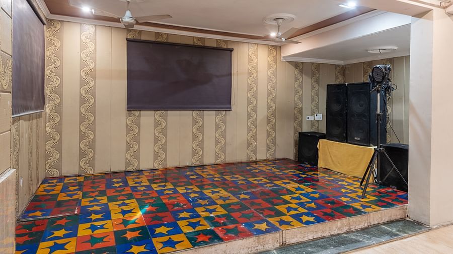 Stage area of the banquet hall with speakers at DLS Park Grace, Haridwar.