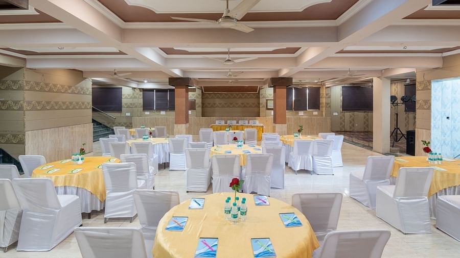 Banquet hall with round tables and chairs at DLS Park Grace, Haridwar.