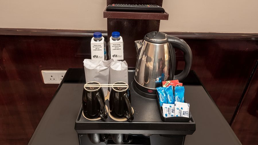 Tea and coffee maker with sugar, beverage sachets, and a kettle at DLS Park Grace, Haridwar.