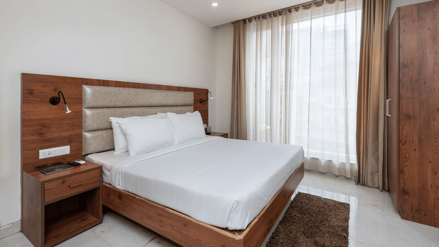 A Deluxe Room featuring a king size bed and a stylish patterned headboard at DLS The Classio
