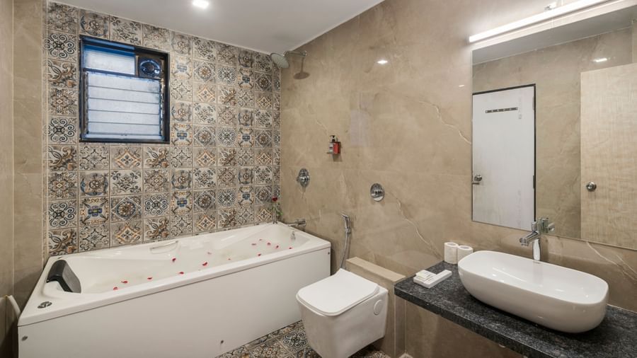 Luxurious bathroom at Emerald Retreat, Tungarli with large jacuzzi bathtub, modern fixtures, and decorative tiles.