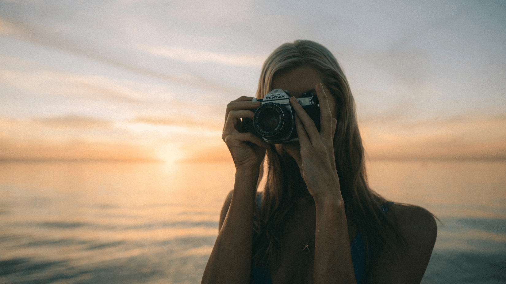 A woman taking photographs with a vintage camera during the golden hour | Photography Havelock