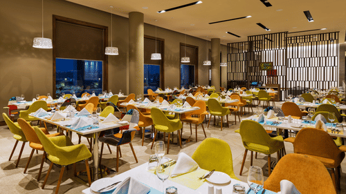 An image of a restaurant with seating arrangement, decorative lighting and items - Pride Elite Phaltan