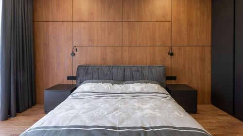 An image of a room with king size bed, bed side table, and a wardrobe