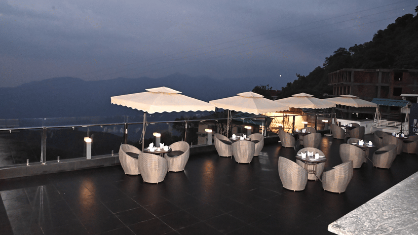 Sky Deck restaurant at Pride Ashiyana Resort Mussoorie featuring outdoor dining setup with a view of hills and valleys.