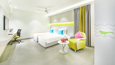 side view of a bedroom featuring a wall-mounted television and a ceiling fan at Zibe Salem by GRT Hotels 