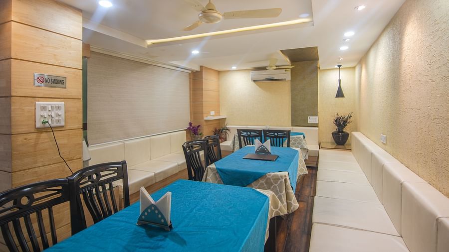 A restaurant with several tables and chairs - Hotel Morya, Bhopal