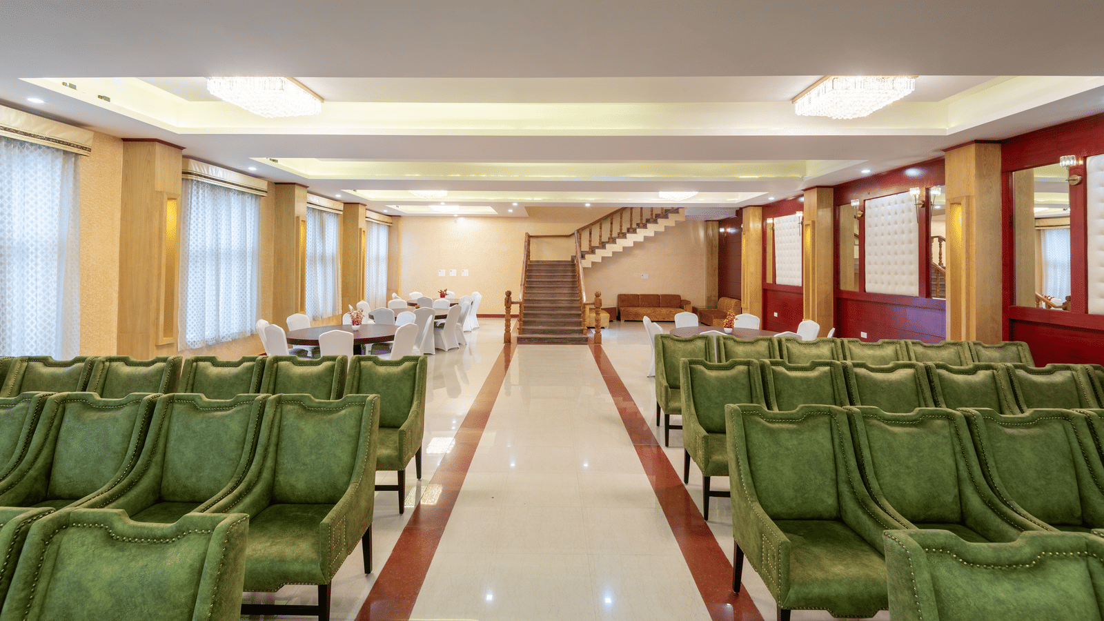 An elegant banquet hall at DLS Hotels showcasing rows of high-back armchairs arranged for a formal presentation.