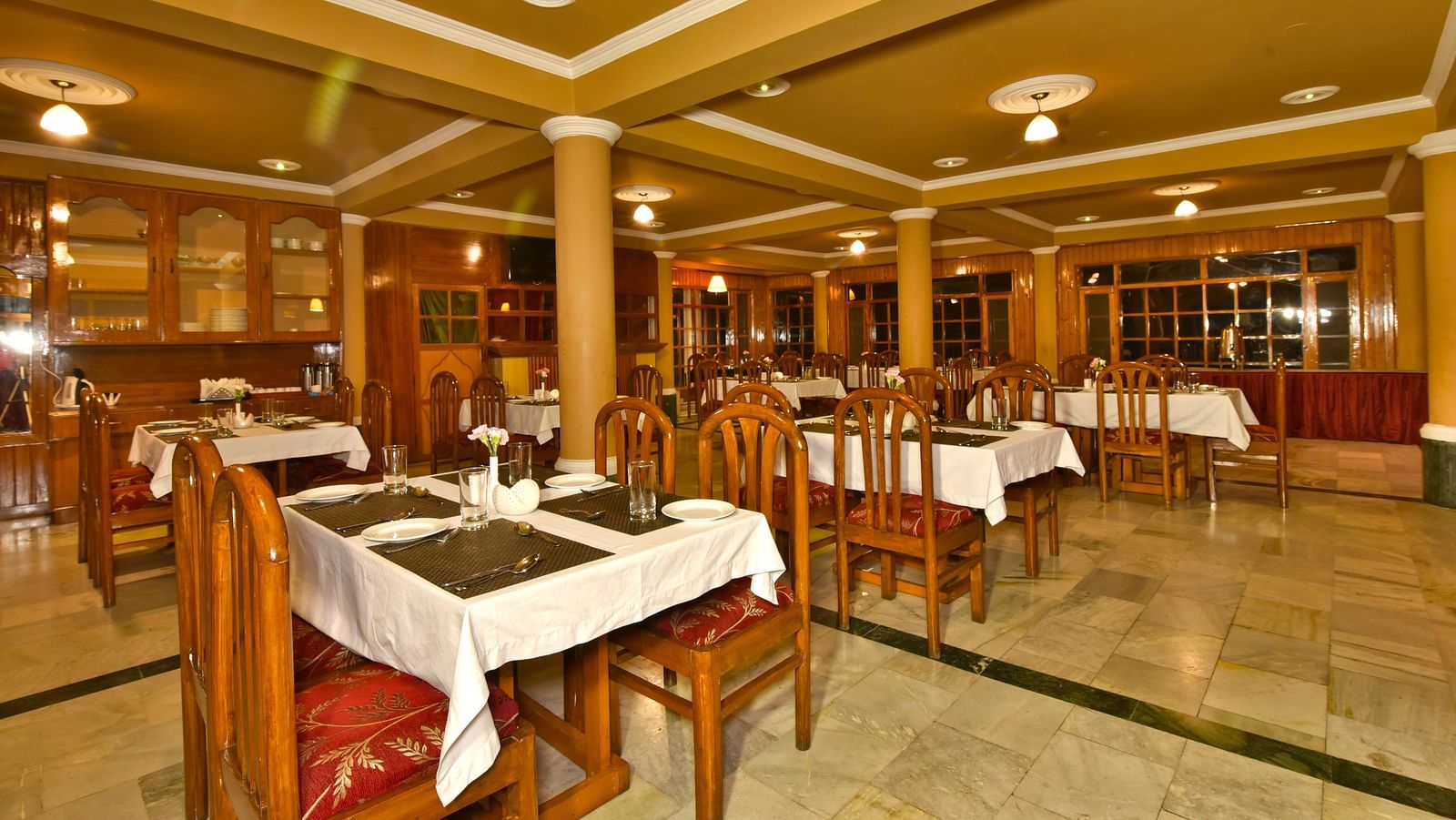 A cosy dining space with tables and chairs at DLS Hillcrest Resort, Shimla.