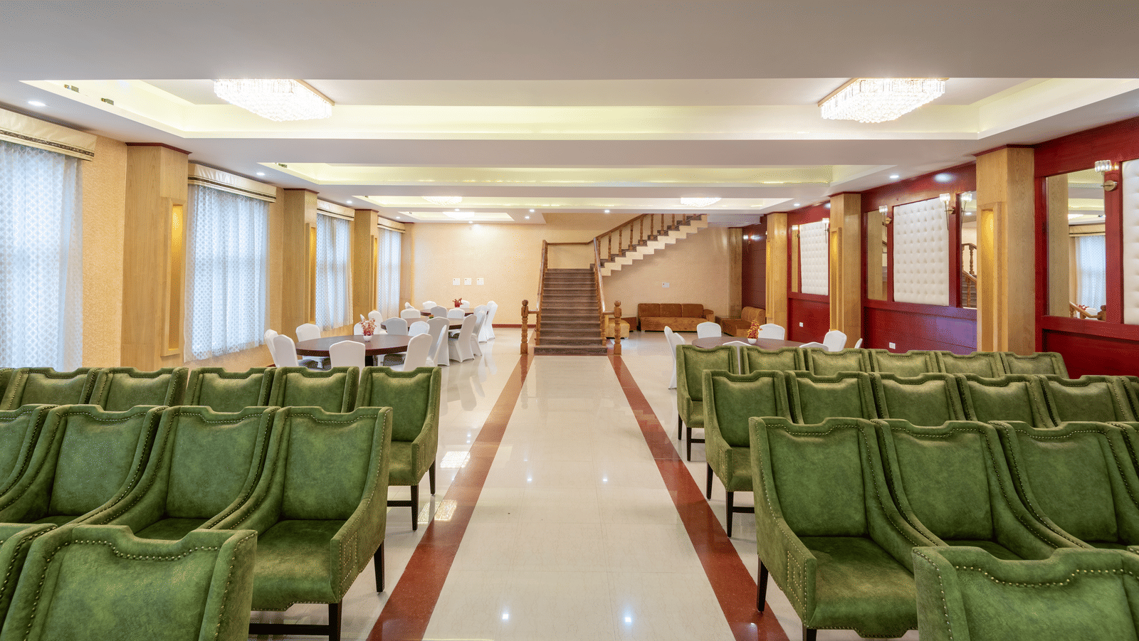 An elegant banquet hall at DLS Hotels showcasing rows of high-back armchairs arranged for a formal presentation.