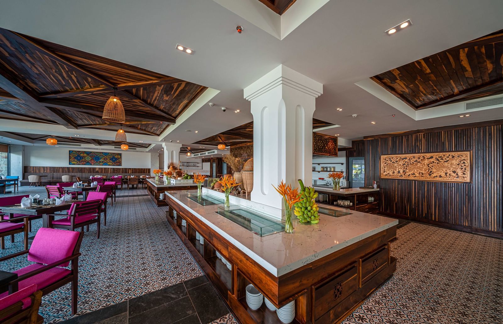 A restaurant at our resort with comfortable seating and a giant pillar in the middle - Alibu Resort Nha Trang